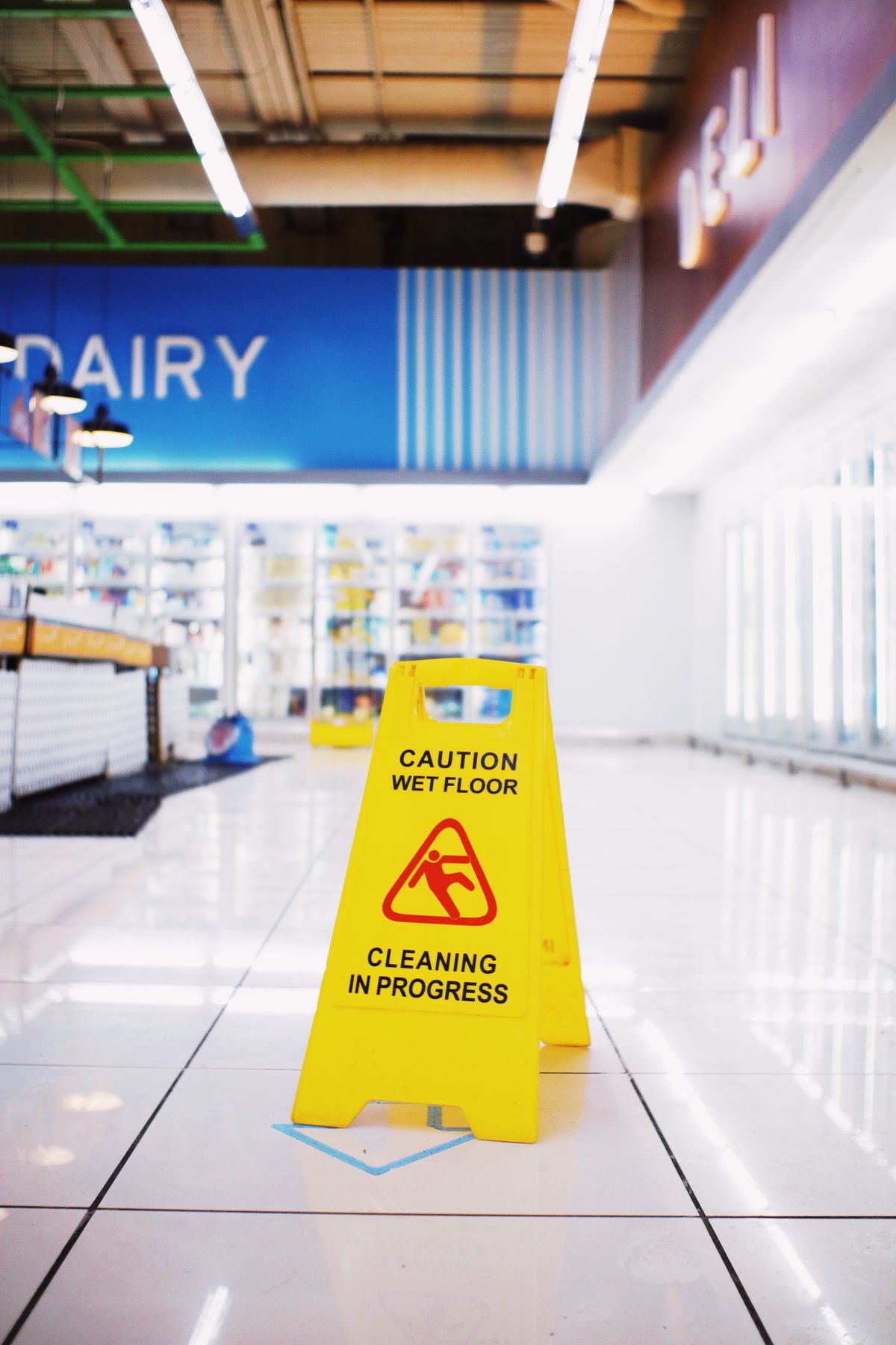 A wet floor sign on a polished floor in a commercial space